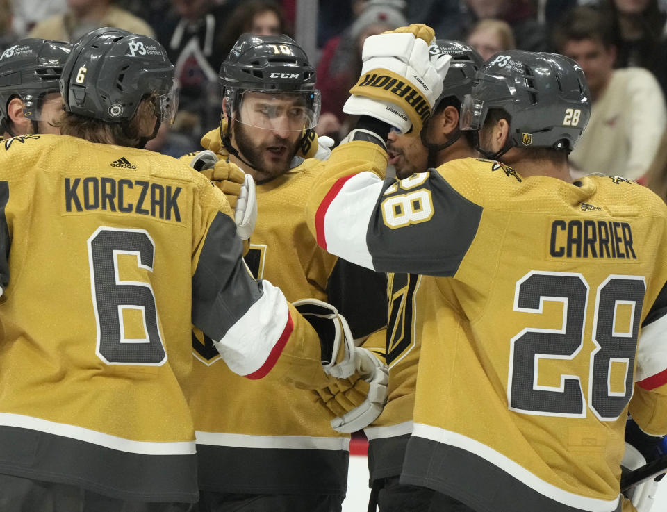 Vegas Golden Knights center Nicolas Roy, center, is congratulated by defenseman Kaedan Korczak, left, and left wing William Carrier after scoring a goal in the second period of an NHL hockey game against the Colorado Avalanche, Monday, Jan. 2, 2023, in Denver. (AP Photo/David Zalubowski)