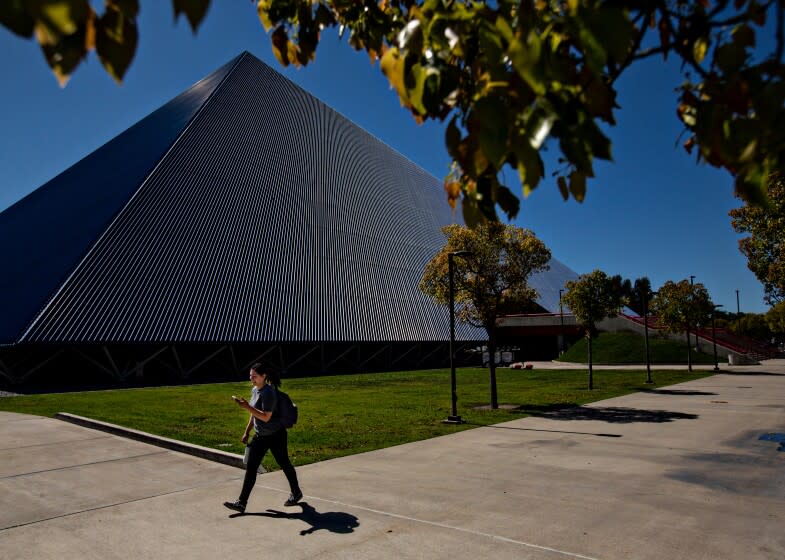 Long Beach, CA., March 11, 2020 - A student passes by The Walter Pyramid at Cal State Long Beach, where the campus has gone to online only classes on Tuesday, March 11, 2020 in Long Beach, California. (Jason Armond / Los Angeles Times)