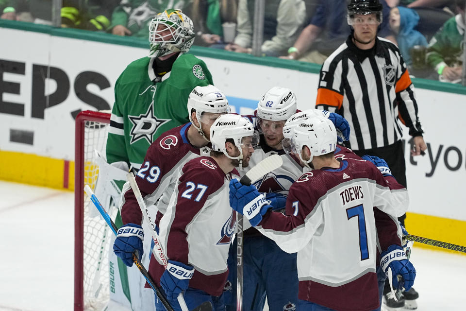 Colorado Avalanche's Nathan MacKinnon (29), Jonathan Drouin (27), Devon Toews (7), Artturi Lehkonen (62) and Cale Makar (8) react after Makar scored a goal against Dallas Stars goaltender Jake Oettinger, top, during the third period in Game 5 of an NHL hockey Stanley Cup second-round playoff series, Wednesday, May 15, 2024, in Dallas. (AP Photo/Tony Gutierrez)