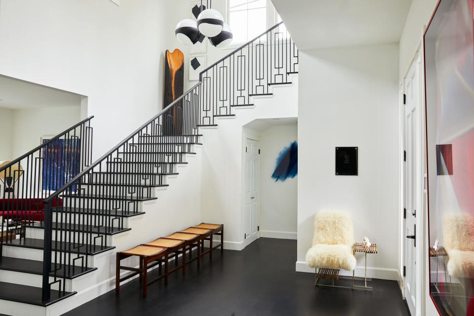 Brazilian design dealer Ulysses de Santi and his husband, art gallery director Graham Steele, live in a West Hollywood home built in 1939. The 5,000-square-foot, two story property, which has clean lines with hints of Cape Cod architecture, provided an ideal setting for the couple’s collection of contemporary art and modernist furniture. “It had great volume and also character,” says De Santi. “By painting the walls white and ebonizing the floors, we were able to create a neutral background and let our art and design speak for itself.” De Santi and Steele may have to explain the telephone chair in the foyer to some of their younger friends. “It’s one of our favorite pieces,” says De Santi. “There’s even a space to put a phone book underneath the seat.” The piece was conceived by Jorge Zalszupin in the 1960s. Next to the stairwell is a jacarandá-and-cane bench by Joaquim Tenreiro, another Brazilian designer from the midcentury.