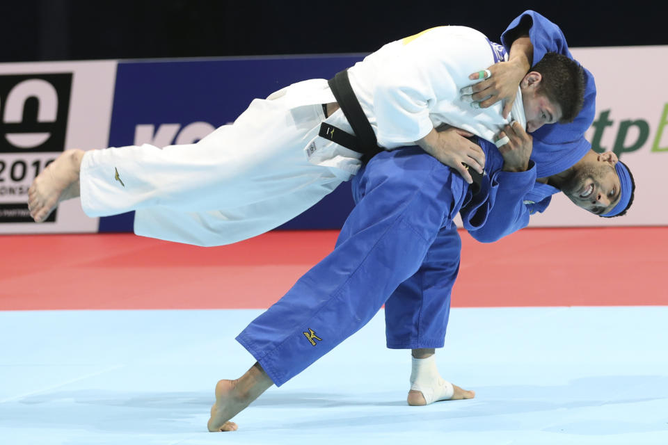 Luka Maisuradze of Georgia, top, competes against Saeid Mollaei of Iran during a men's -81 kilogram bronze medal match of the World Judo Championships in Tokyo, Wednesday, Aug. 28, 2019. (AP Photo/Koji Sasahara)