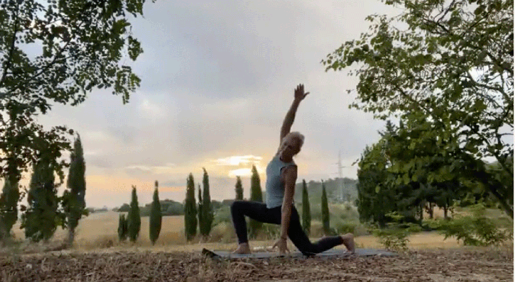 Woman practicing an early morning yoga routine with a side stretch in low lunge