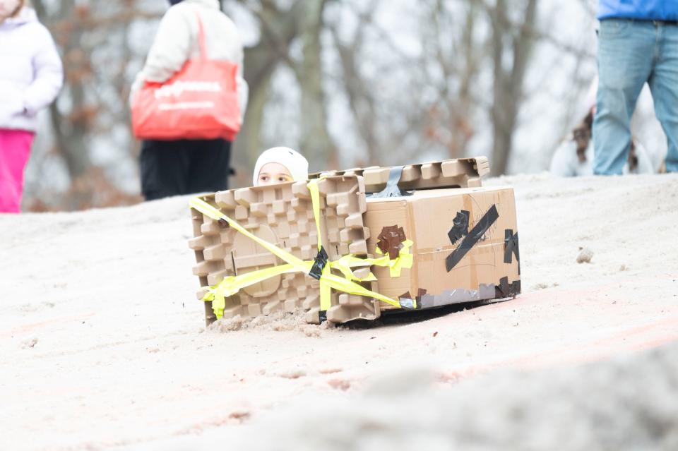 A competitor looks out from the 'Imposter Among Us' sled on the hill in the Festivus Cardboard Sled Competition at Leila Arboretum on Saturday, Feb. 10, 2024.