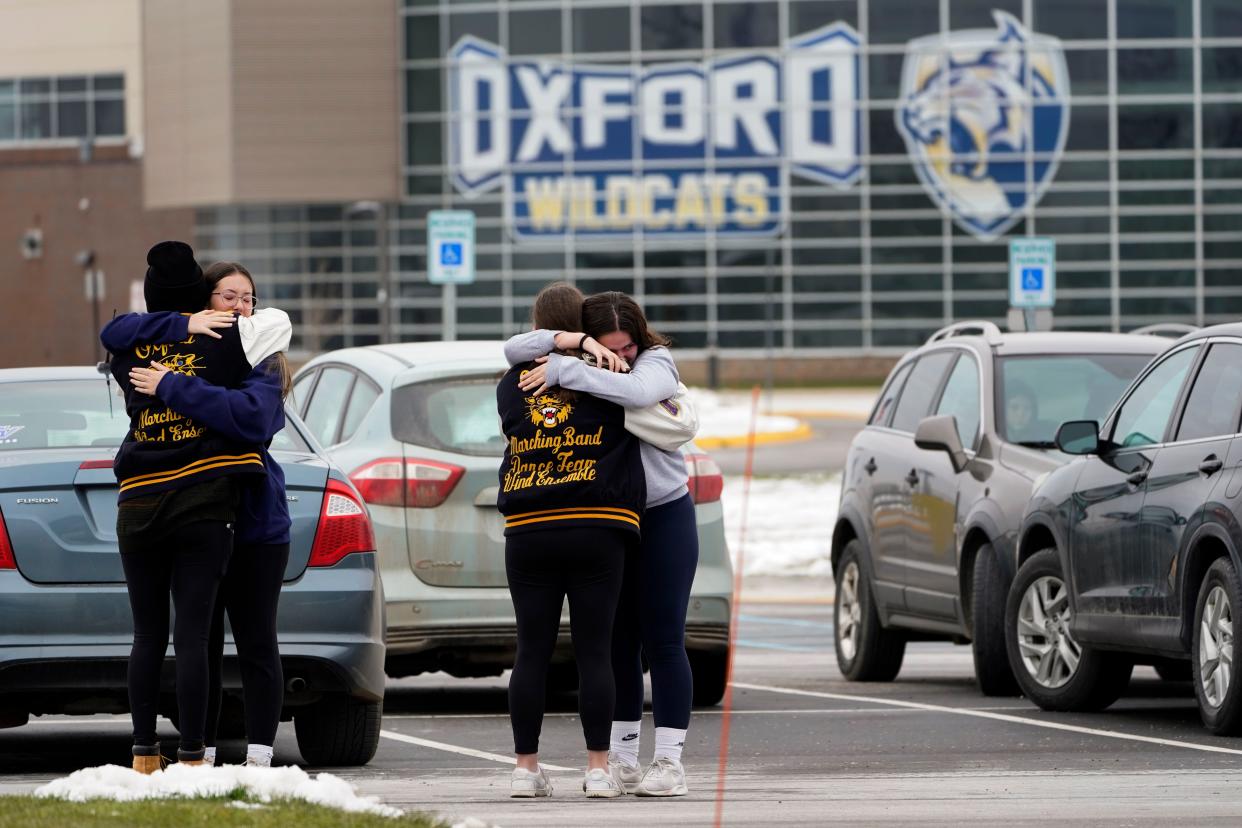 Students hug at outside Oxford High School in Oxford, Mich., Wednesday, Dec. 1, 2021. 