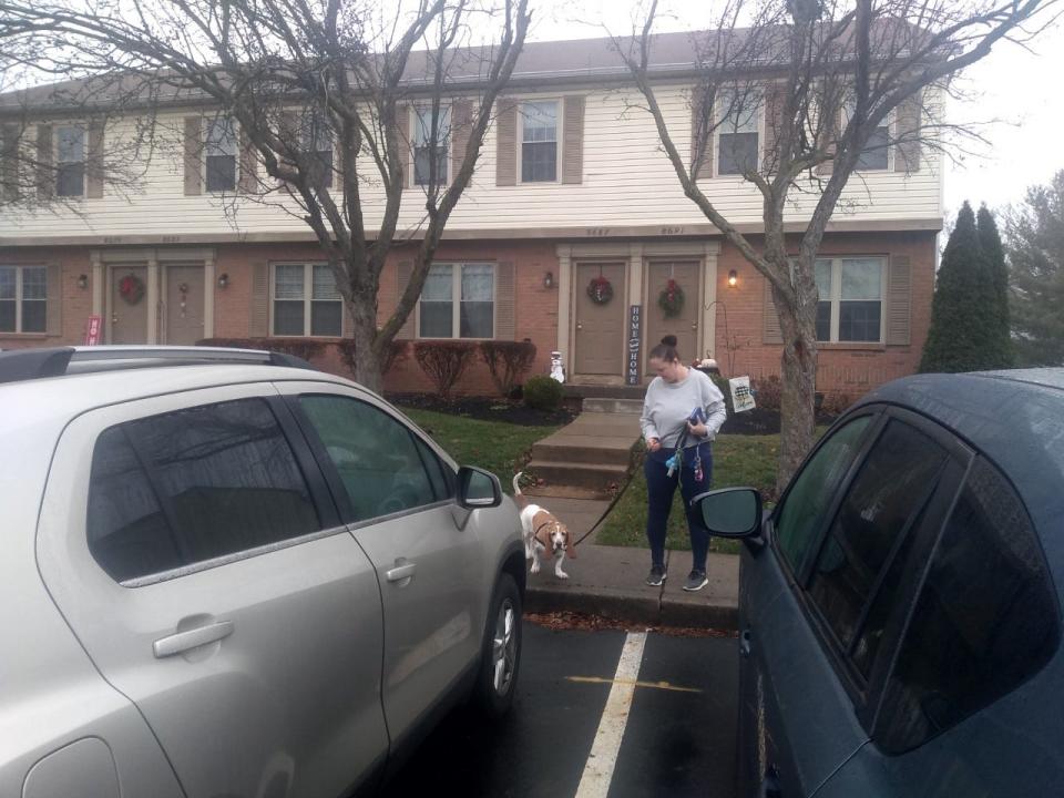 Dawn Rader takes her basset hound, Olive, out for a walk. Proposed parking fees for both of her cars, shown, would cost her almost $3,000 annually. That's why she's refusing to sign a lease agreement requiring it.