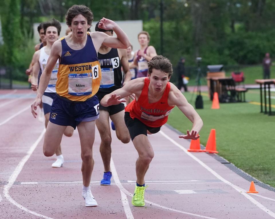 Ridgefield, Connecticut's Steven Hergenrother (R) talls over the finish line for the boys 200 win afer he and  runner-up Cameron Miles (l) of Weston, Ct. made made contact in the race's last few strides during the 56th annual Loucks Games May 10, 2024 at Whtie Plains High School.
