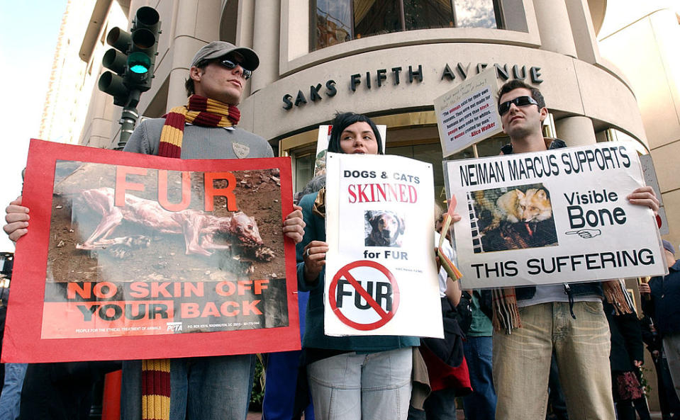 Demonstrators from In Defense of Animals holds a sign as police officers block the entrance to Neiman Marcus in San Francisco in 2022 for an anti-fur protest.