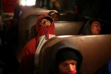 Migrant farmworkers with H-2A visas sleep on the bus from their labor camp to the fields to harvest romaine lettuce before dawn in King City, California, U.S., April 17, 2017. REUTERS/Lucy Nicholson/Files