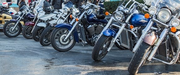 Line of motorcycles parked on a paved surface.