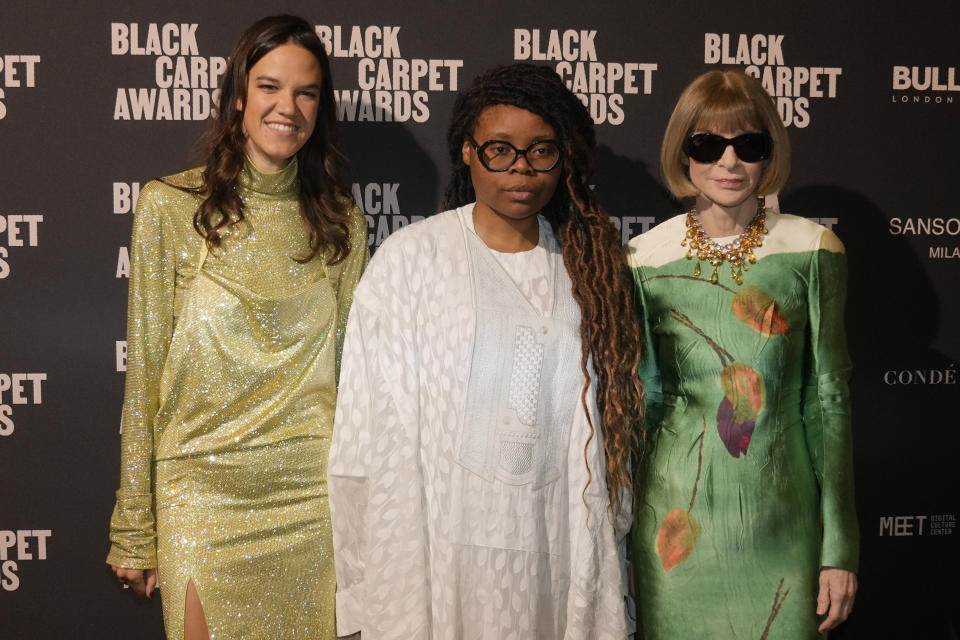 Afro Fashion Association founder Michelle Ngonmo, center, is flanked by Anna Wintour, right, and Vogue Italy director Francesca Ragazzi as they attend the first edition of the 'Black carpet awards', in Milan, Italy, Friday, Feb. 24, 2023. The founder of the Afro Fashion Association in Italy on Thursday said she is launching awards recognizing the achievements of minorities in Italian society, to promote greater diversity and inclusion. (AP Photo/Luca Bruno)