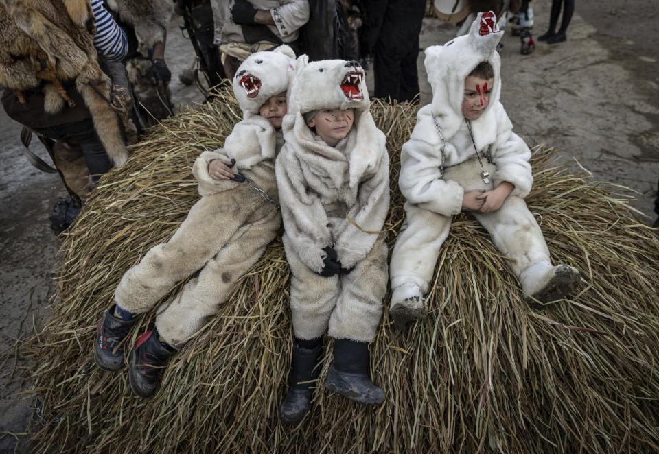 Children dressed in bear costumes, pose for a photo while celebrating the Malanka festival in the village of Krasnoilsk, Ukraine, Friday, Jan. 14, 2022. (AP Photo/Ethan Swope)