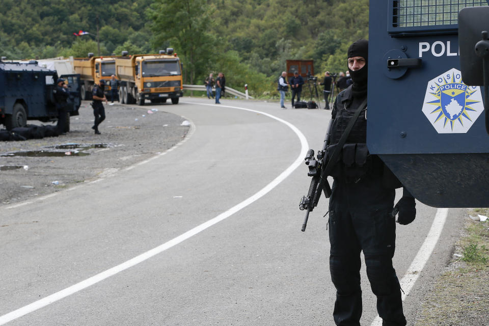 Kosovo police officers patrol a road near the northern Kosovo border crossing of Jarinje, Tuesday, Sept. 21, 2021. Tensions soared Monday when Kosovo special police with armored vehicles were sent to the border to impose a rule on temporarily replacing Serb license plates from cars while they drive in Kosovo. (AP Photo/Visar Kryeziu)