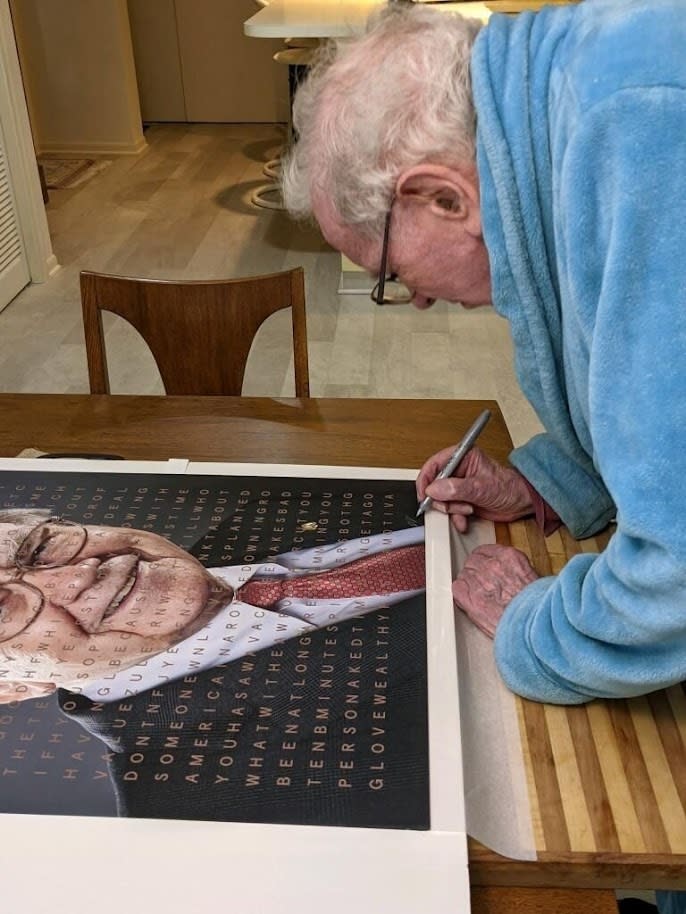 FILE - Billionaire Warren Buffett signs a portrait of himself that is being auctioned off to raise money for one of his favorite charities, Girls Inc. of Omaha, Neb. The portrait of Buffett features a grid of letters over the picture that light up to spell out several of the legendary investor’s famous quotes. The eBay auction of this artwork probably won't rival the $19 million someone paid earlier this year for a private lunch with Buffett, but it's still likely to attract big bidders among the Berkshire Hathaway CEO's devoted followers.CEO's devoted followers. (Motiva Art via AP)