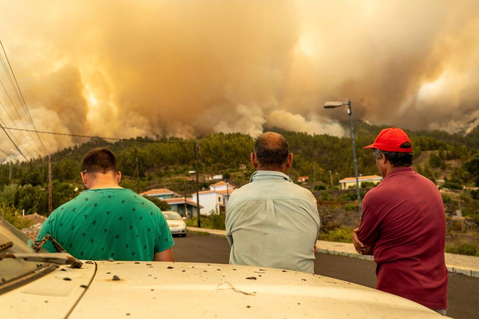Local residents look on at a burning forest fire, near Puntagorda on the Canary Island of La Palma (AP)