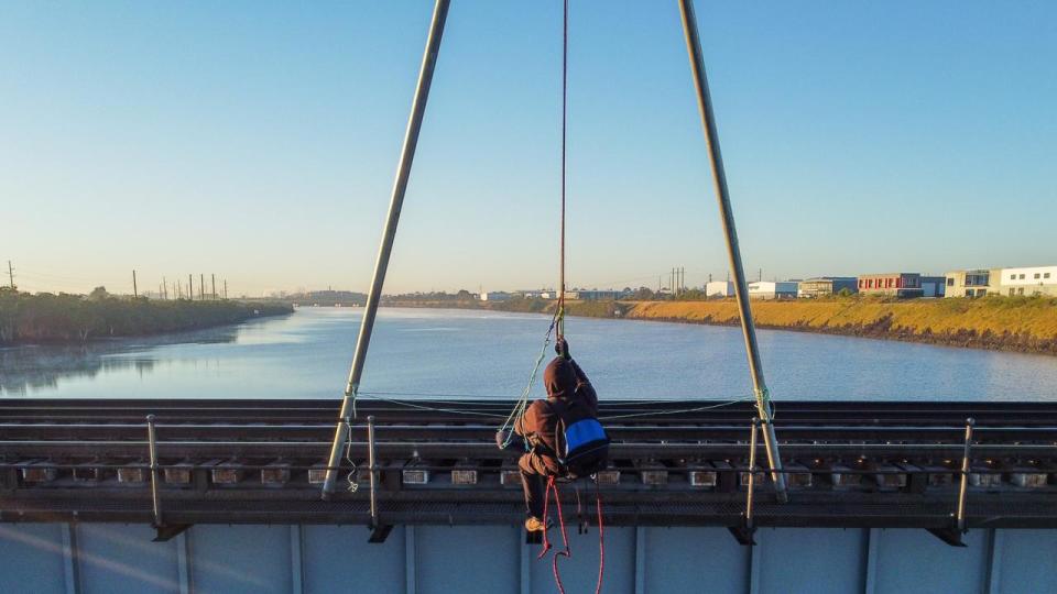 Ian Fox, 76, has climbed atop the Kooragang Rail Bridge and suspended himself over the Hunter River. Picture: Blockade Australia