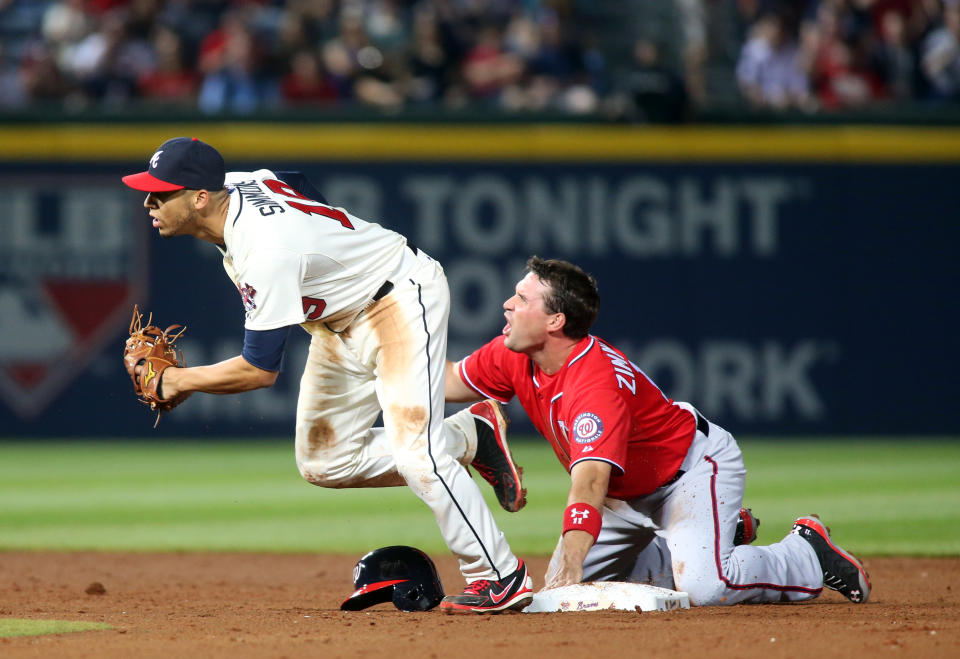 Washington Nationals' Ryan Zimmerman, right, reacts after being tagged out by Atlanta Braves shortstop Andrelton Simmons, left, at second base on a pickoff by Braves starting pitcher Alex Wood in the fifth inning of a baseball game on Saturday, April 12, 2014, in Atlanta. (AP Photo/Jason Getz)