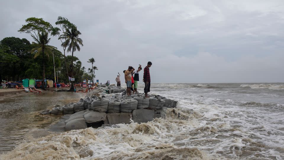 Locals stand near the sea as Cyclone Remal made landfall in Bangladesh on May 26, 2024. - K M Asad/LightRocket/Getty Images