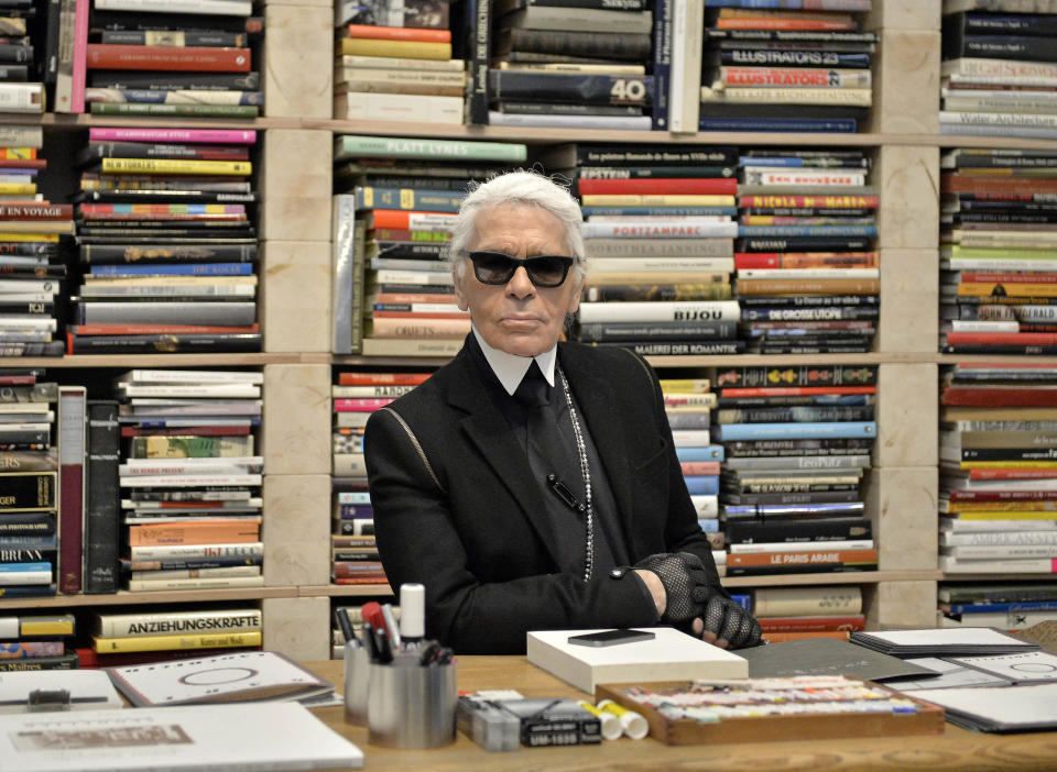 Fotografía de archivo del 14 de febrero de 2014 del diseñador de modas Karl Lagerfeld frente a sus libros antes de la inauguración de una exhibición en el museo Folkwang en Essen, Alemania. (AP Foto/Martin Meissner, Archivo)