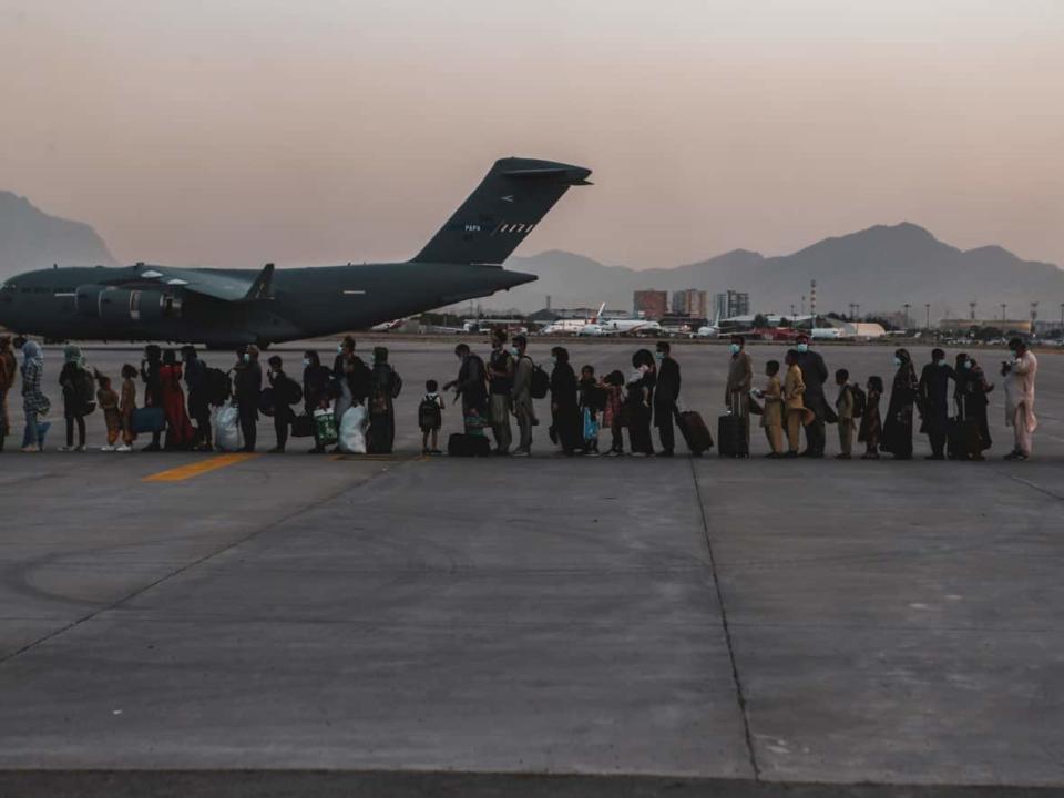 Evacuees wait to board a Boeing C-17 Globemaster III during an evacuation at Hamid Karzai International Airport in Kabul, Afghanistan, on Aug. 23. (U.S. Marine Corps/Reuters - image credit)