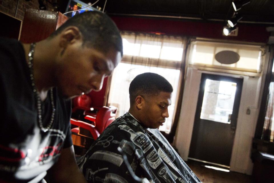 Keith Wilson, right, get his haircut by Corey Cooper at a barbershop in East Atlanta, Ga., in Dekalb County, Thursday, Jan. 5, 2017. "I'm as cynical now as I was then," said Wilson of how he feels since Donald Trump won the election. "But I'm not going to pay him attention unless he starts a war with China. I'm going to feed my family and continue living my life." (AP Photo/David Goldman)