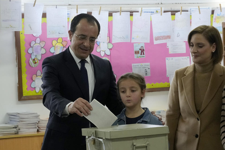 Presidential candidate and former foreign minister Nikos Christodoulides casts his vote as he is accompanied by his wife Philippa and his daughter during the presidential elections in Geroskipou in south west coastal city of Paphos, Cyprus, Sunday, Feb. 5, 2023. Cypriots began voting for their eighth new president in the ethnically divided island’s 62-year history as an independent republic, with three front-runners each portraying themselves as the safest bet to guide the country through turbulent economic times and to seek peace with breakaway Turkish Cypriots. (AP Photo/Petros Karadjias)