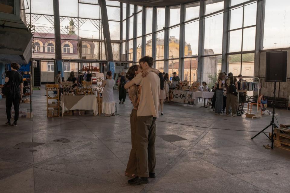 A couple dances as others visit a charity fair in Zhytniy Market on June 17, 2023 in Kyiv, Ukraine. The main goal of the event was to collect money for one of Ukraine's army units. (Roman Pilipey/Getty Images)