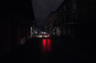 Los faros de un automóvil iluminan la calle Bourbon sumida en un apagón debido al paso del huracán Zeta el miércoles 28 de octubre de 2020, en el Barrio Francés de Nueva Orleans. (AP Foto/Gerald Herbert)