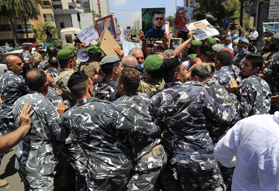 The private security forces of of parliament speaker Nabih Berri, push back the families of the victims of last year's massive blast at Beirut's seaport, as they protest and try to reach his tightly-secured residents, in Beirut, Lebanon, Friday, July 9, 2021. The protest came after last week's decision by the judge to pursue senior politicians and former and current security chiefs in the case, and requested permission for their prosecution. (AP Photo/Hussein Malla)