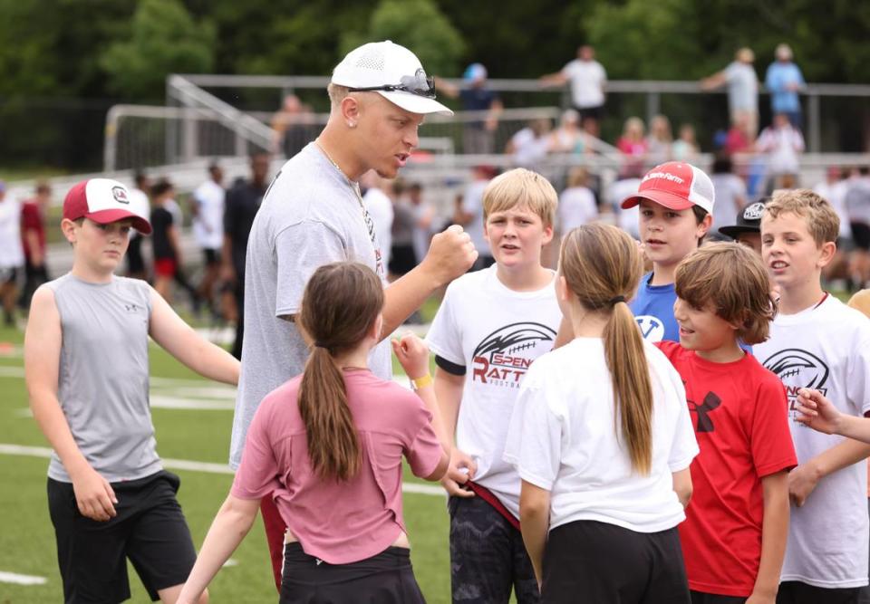 South Carolina quarterback Spencer Rattler works with kids attending the Spencer Rattler FlexWork Football Camp at Dreher High School in Columbia on Saturday, May 20, 2023.