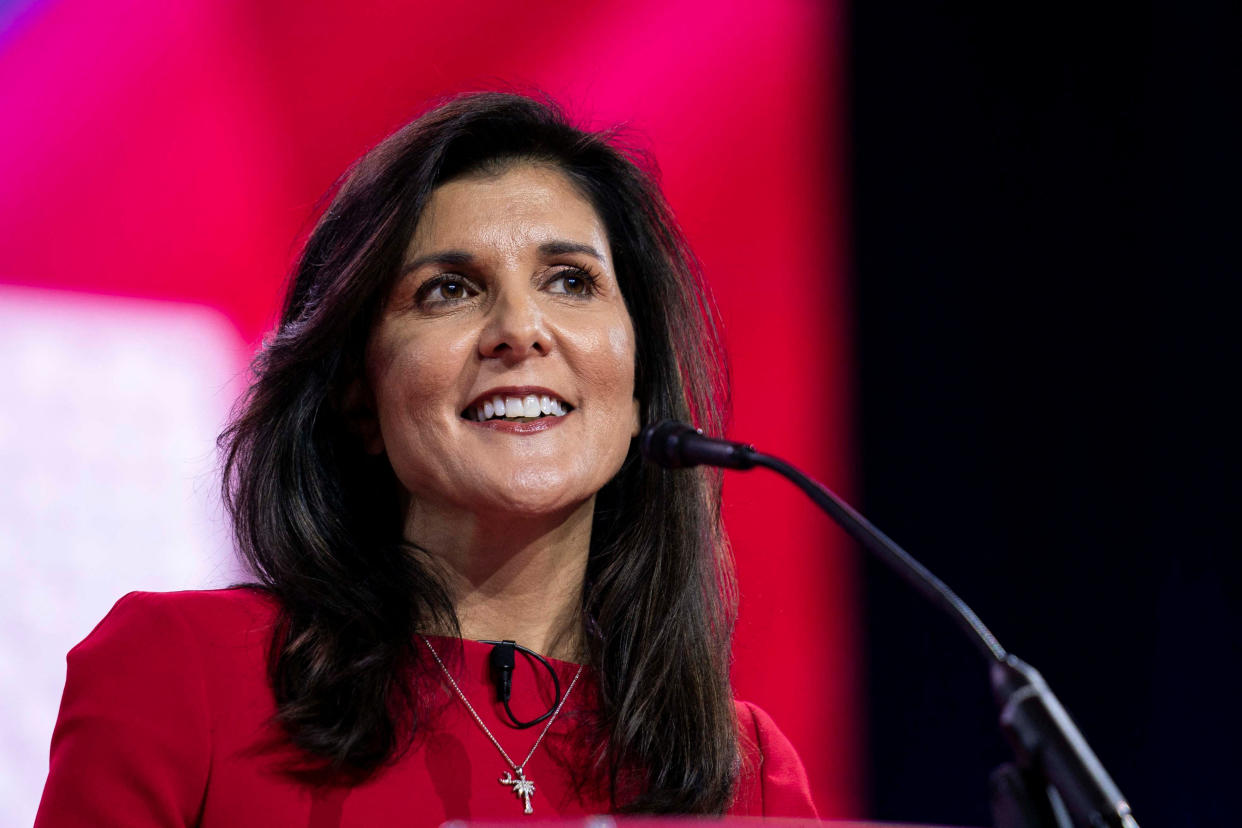 Nikki Haley, smiling, at the microphone.