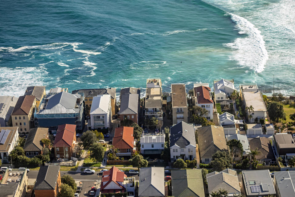 Aerial photography of property on coastline with ocean, surf, waves. 