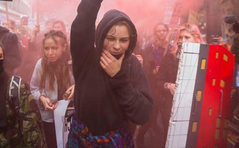 Student holds lit flare in London street - Credit: Warren Allott for The Telegraph