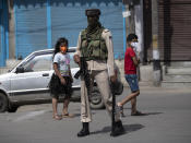 Kashmiri children walk past a paramilitary soldier during curfew in Srinagar, Indian controlled Kashmir, Tuesday, Aug. 4, 2020. Authorities clamped a curfew in many parts of Indian-controlled Kashmir on Tuesday, a day ahead of the first anniversary of India’s controversial decision to revoke the disputed region’s semi-autonomy. Shahid Iqbal Choudhary, a civil administrator, said the security lockdown was clamped in the region’s main city of Srinagar in view of information about protests planned by anti-India groups to mark Aug. 5 as “black day." (AP Photo/Mukhtar Khan)