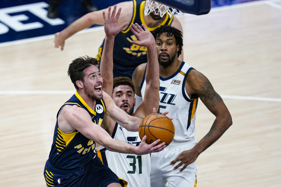 Indiana Pacers guard T.J. McConnell (9) shoots in front of Utah Jazz forward Georges Niang (31) during the second half of an NBA basketball game in Indianapolis, Sunday, Feb. 7, 2021. (AP Photo/Michael Conroy)