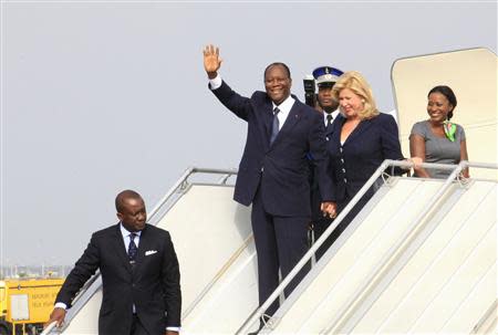 Ivory Coast's President Alassane Ouattara (L) waves next to wife Dominique (R) as they arrive at Felix Houphouet-Boigny international airport in Abidjan March 2, 2014. REUTERS/Thierry Gouegnon