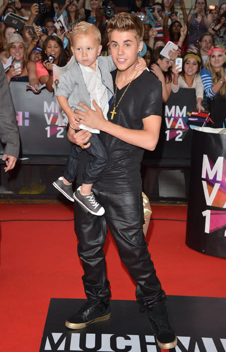 Who cares what Justin Bieber is wearing, just look at his adorable (and stylish) little brother! Biebs Jr. is red carpet ready with a grey jacket over a white dress shirt and wears shiny jeans that match his big brother's outfit and cute slate Chucks. Bieber meanwhile ups his bling factor with a large gold red cross and a metallic shirt and matching jeans. And are those gold sneakers? (Photo by George Pimentel/WireImage)