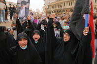 Followers of Shiite cleric Muqtada al-Sadr hold posters with his photo as they celebrate the passing of a law criminalizing the normalization of ties with Israel, in Tahrir Square, Baghdad, Iraq, Thursday, May 26, 2022. (AP Photo/Hadi Mizban)