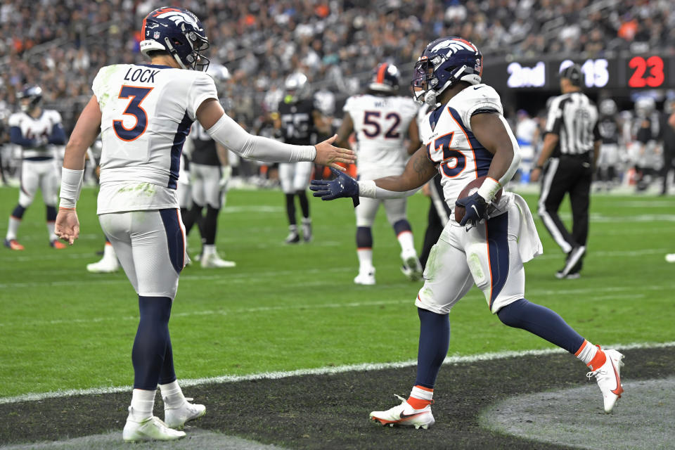 Denver Broncos quarterback Drew Lock (3) celebrates after running back Javonte Williams, right, scored a touchdown against the Las Vegas Raiders during the first half of an NFL football game, Sunday, Dec. 26, 2021, in Las Vegas. (AP Photo/David Becker)