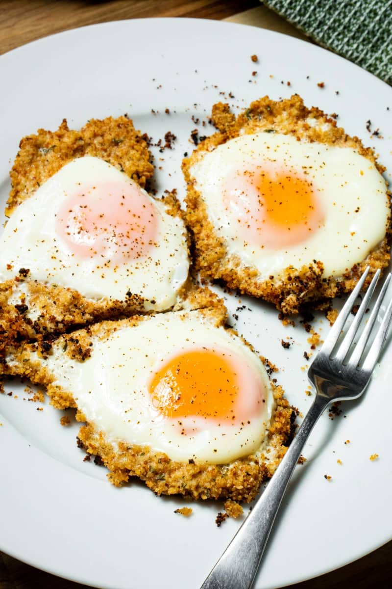 Fried eggs on bed of breadcrumbs on plate