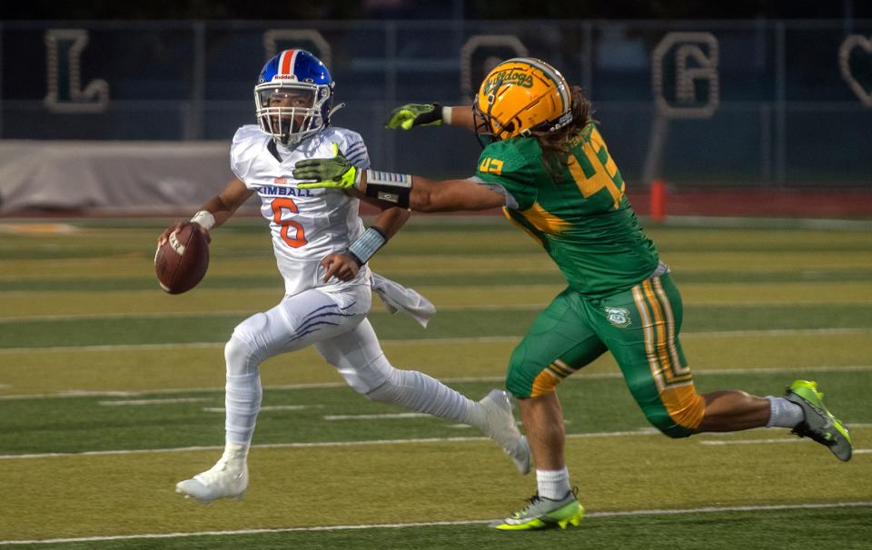 Kimball's Josiah Wilson, left, is chased by Tracy's Maxwell Laird during a varsity football game at Tracy's Wayne Schneider Stadium in Tracy.