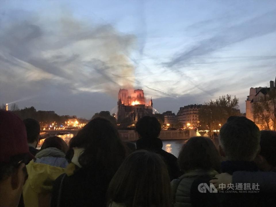 巴黎聖母院起火時，周圍人行道、橋上、河堤邊站滿許多人，神情肅穆、不發一語地看著火光與濃煙侵略這座存在超過850年的歷史建築。（中央社）