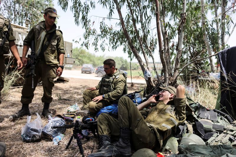 Israeli soldiers sit near border with Gaza Strip following Israel-Hamas truce