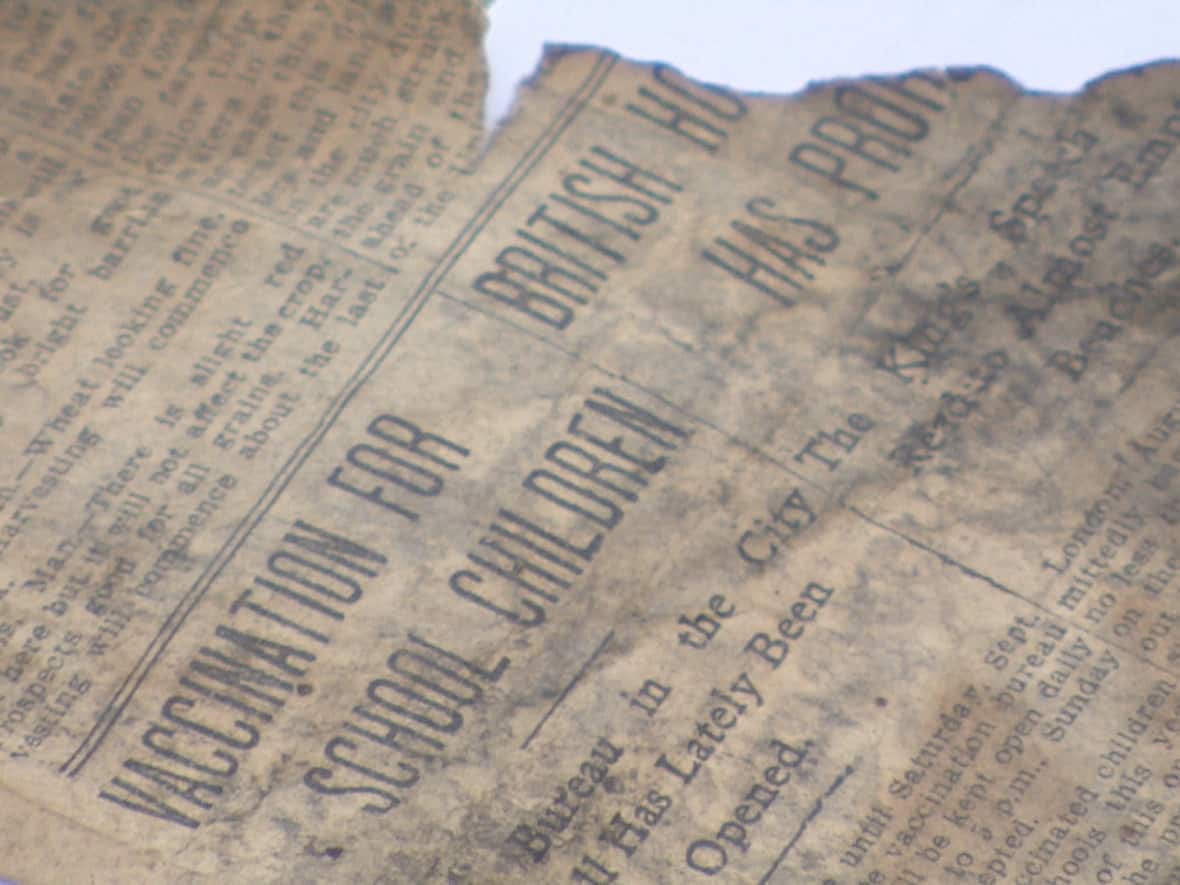 While demolishing a church in McAdam, N.B., crews came across a tattered piece of newsprint that featured a story about vaccination for school children in Montreal. (Ed Hunter/CBC - image credit)