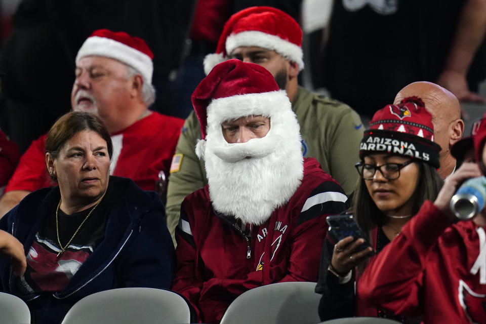 Fans dressed as Santa Claus prior to an NFL football game between the Indianapolis Colts and the Arizona Cardinals, Saturday, Dec. 25, 2021, in Phoenix. (AP Photo/Ross D. Franklin)