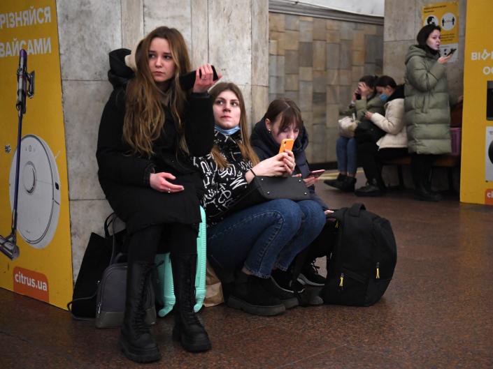 Girls hold their mobile phone as they take refuge in a metro station in Kyiv, Ukraine on Thursday morning local time amid a Russian assault on their country.