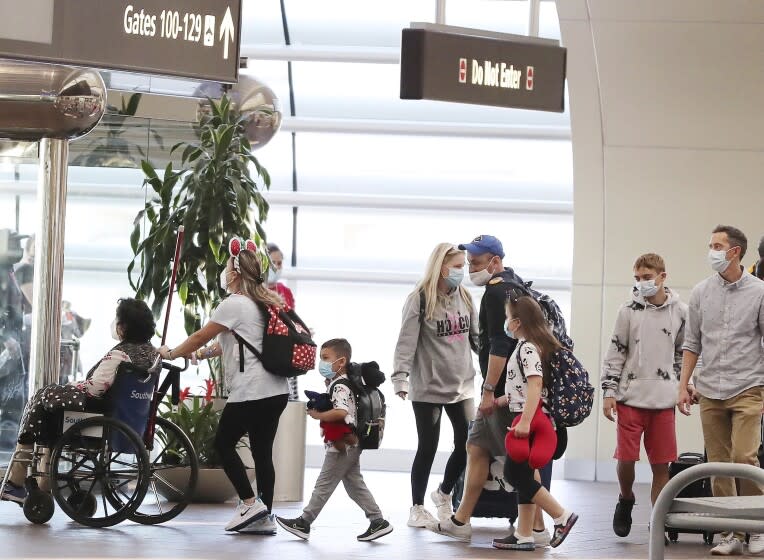 Travelers walk through Terminal A at Orlando International Airport on Christmas Day, Saturday, Dec. 25, 2021. (Stephen M. Dowell/Orlando Sentinel via AP)