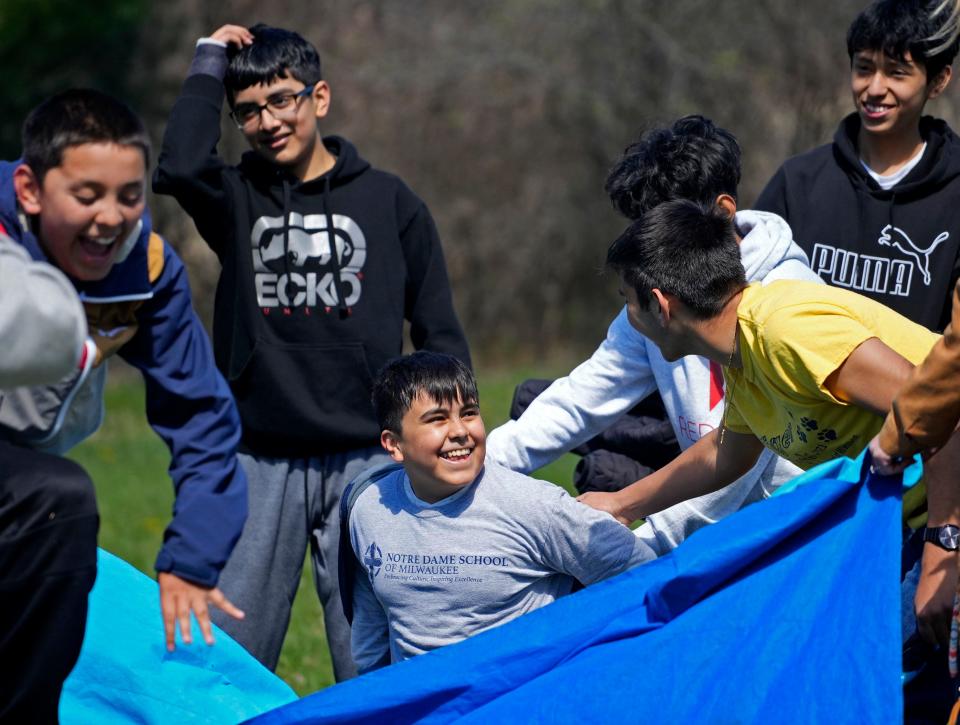 Allan Marquez, center, and other students from Notre Dame Middle School react during a team-building game at Catholic Ecology Center in Neosho.