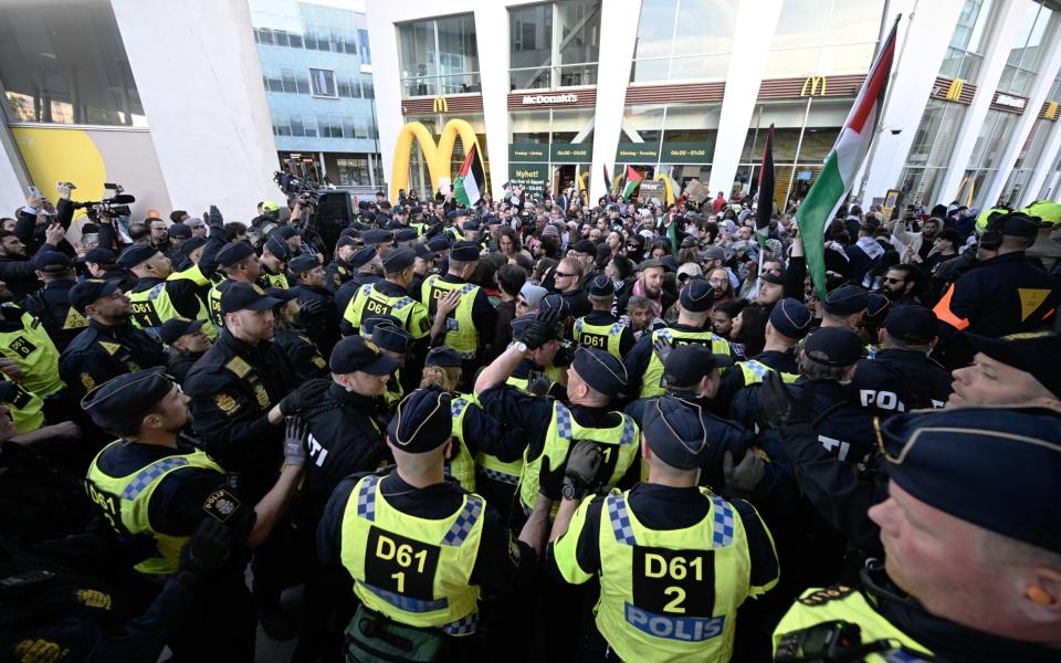 Protesters face a wall of police outside the arena