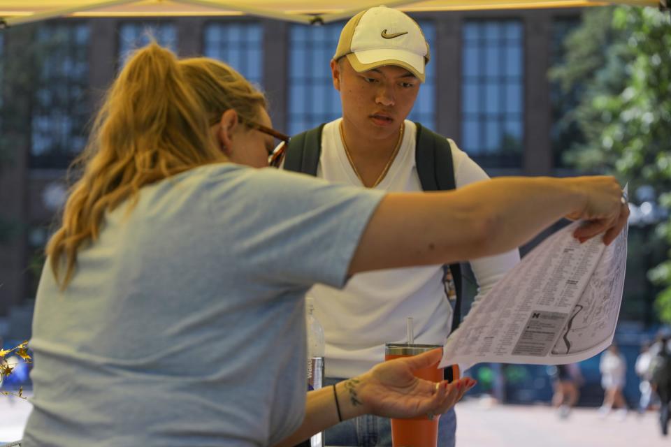 Leopold Hoang, 18, of Houston, stops for directions at an information station on the Diag after the internet went down on Sunday at the University of Michigan in Ann Arbor, Mich. on Tuesday, Aug. 29, 2023. Hoang says he hasn't even been able to get his syllabi yet and that it's been "a shaky start to his freshman year." Hoang is concerned that his work will pile up without access to the internet and he won't be able to finish his assignments in time.