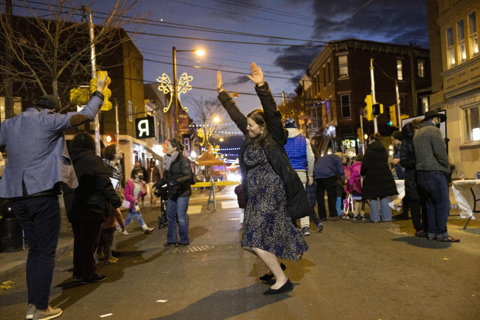 Rabbanit Dasi Fruchter, of the South Philadelphia Shtiebel, dances in the street during a public Hanukkah celebration and menorah lighting ceremony in South Philadelphia on Sunday, Dec. 5, 2021. Fruchter is one of about a half-dozen ordained women who serve Modern Orthodox synagogues across the U.S. and one of even fewer who serve as top spiritual leaders. (AP Photo/Ryan Collerd)